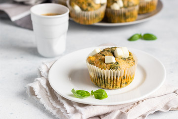 Freshly baked muffins with spinach and feta cheese. Light background. Copy space.