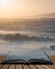 Stunning foggy English rural landscape at sunrise in Winter with layers rolling through the fields...