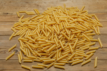 hard and short pasta on a light, old wooden board