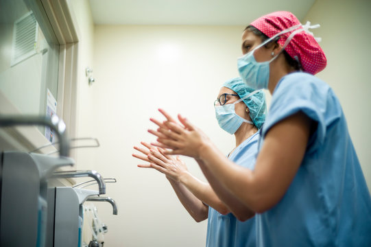 Two Female Surgeon Doctors Wash Their Hands Before The Operation.