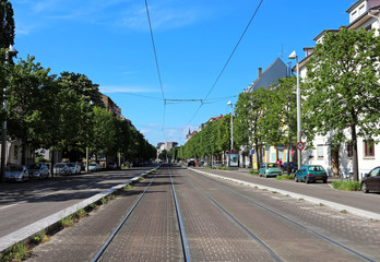 Fototapeta na wymiar Street perspective with tramway lines in the middle
