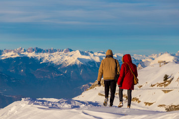 Coppia sulla neve a Cima Grappa con in vista le Dolomiti