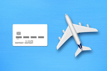 Credit card mock-up and toy airplane on blue table top view