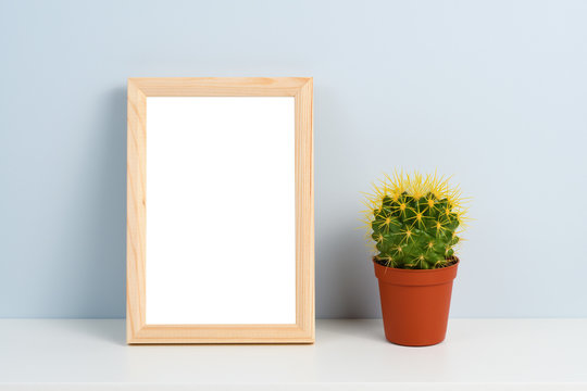 Cactus In Pot And Wooden Photo Frame On Shelf