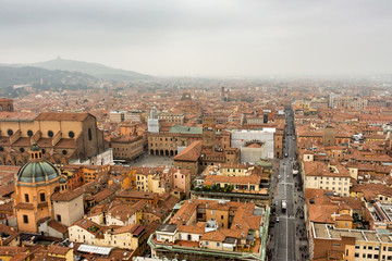 Fototapeta na wymiar Aerial view of Bologna, Italy and its main square (Piazza Maggiore) on a fogy fall day. Cityscape from Asinelli tower.