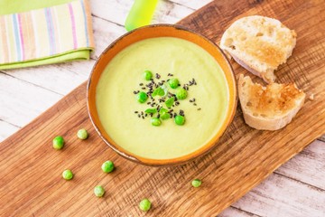 Homemade cream soup with green peas and black sesame seeds