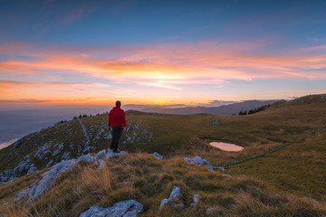 Escursionista uomo in cima alla montagna al tramonto, Cansiglio, Fregona , Veneto
