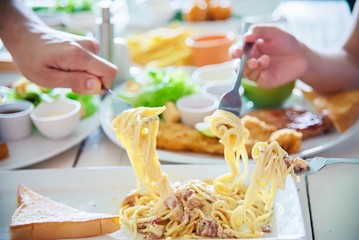 People enjoy eat spaghetti together in a big meal set - family happy time with food concept