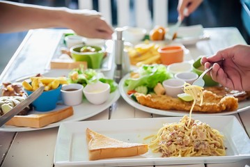 People enjoy eat spaghetti and steak together in a big meal set - family happy time with food concept
