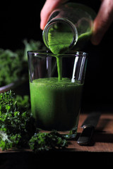 Kale smoothie. Pouring a glass with smoothie