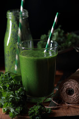 Green kale smoothie on rustic wooden background