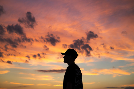 Side view of man standing against cloudy sky during sunset - Powered by Adobe