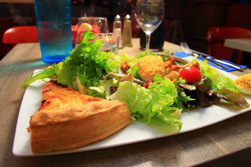 Salad prepared with mimosas eggs and a portion of onion pie in a French restaurant