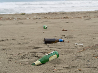 trash on the beach: beer bottles abandoned on the sand - 247869259