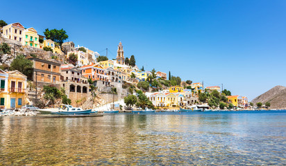 Fototapeta na wymiar Anchored boats and colorful neoclassical houses in bay of Symi (Symi Island, Greece)