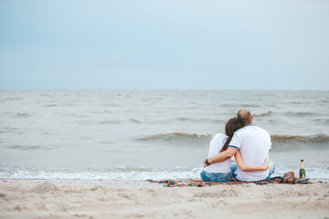 couple in love sitting back on the beach by the sea, honeymoon, romance, together