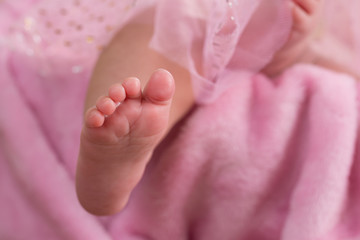 baby girl feet on pink blanket