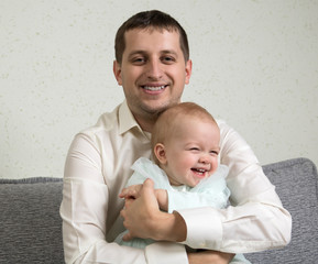 Father hugs baby they radiate joy, fun, and happiness