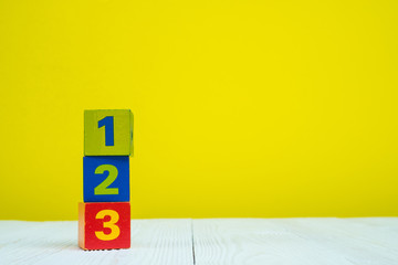 Square block puzzle number 1 2 and 3 on table with yellow background