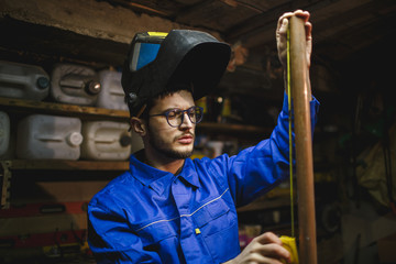 Portrait of a serious man working with a measuring instrument in his workshop