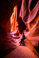 Impressed young traveler woman looking up inside of the Antelope Canyon, Arizona, USA.  - obrazy, fototapety, plakaty