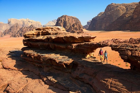 Couple hiking at Rock Arch, Al Borg Alsagheer, Wadi Rum, Jordan, Asia