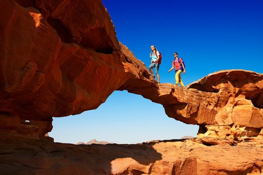 Couple hiking at Rock Arch, Al Borg Alsagheer, Wadi Rum, Jordan, Asia