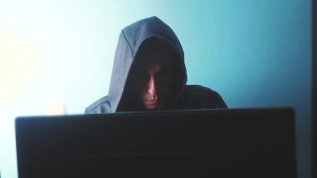 man hacker in the hood concept. unknown hacker criminal breaks into computer lifestyle protection on the Internet passwords. male hacker penetrates into hack network protection web phishing technology
