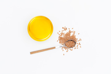 Flax oil and flax seeds in a spoon isolated on white background. Flat lay. Top view