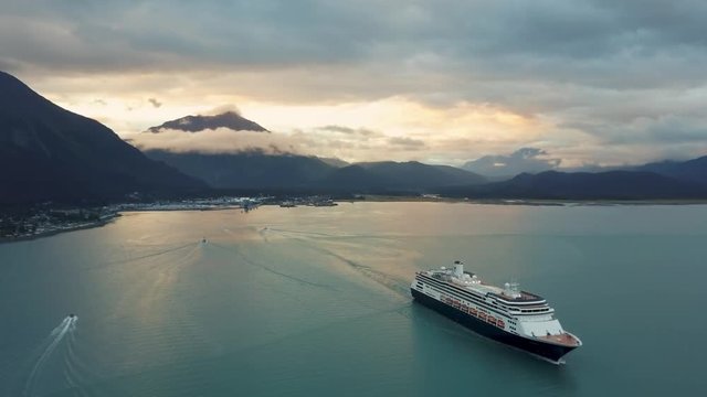 Cruise ship in beautiful Seward Alaska as sun sets in the distance, Aerial View, 4k