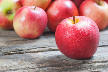 Fresh organic ripe red apples with water drops on wooden background, Apple fruit concept