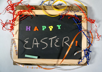 Happy Easter message on chalkboard with colorful ribbon and letters