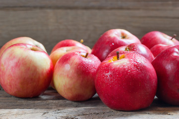 Fresh organic ripe red apples with water drops on wooden background, Apple fruit concept