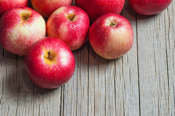 Fresh organic ripe red apples with water drops on wooden background, Apple fruit concept