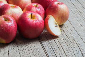 Fresh organic ripe red apples with water drops on wooden background, Apple fruit concept
