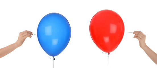 Women piercing colorful balloons on white background © New Africa