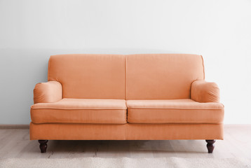 Orange sofa in living room near white wall