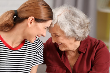 Elderly woman with female caregiver on blurred background