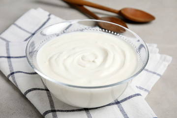 Glass bowl with creamy yogurt served on table