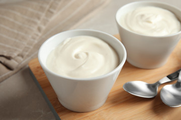 Bowls with creamy yogurt served on table