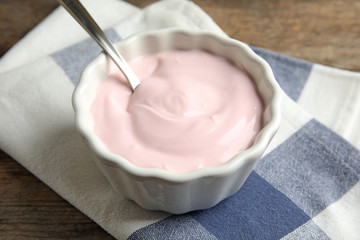 Bowl with creamy yogurt served on table