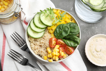 Healthy quinoa salad with vegetables in bowl served on table, top view
