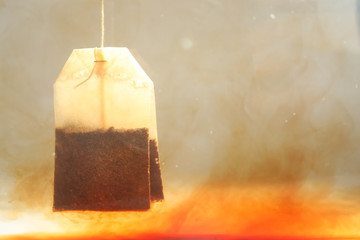 Brewing tea with bag in hot water, closeup. Space for text
