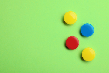 Bright magnets on color background, top view with space for text