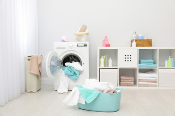 Bathroom interior with dirty towels in basket and washing machine