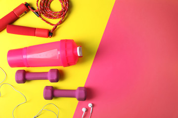 Flat lay composition with fitness gym equipment on color background. Space for text