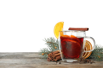Composition with glass cup of mulled wine, cinnamon, orange and fir branch on table against white background. Space for text
