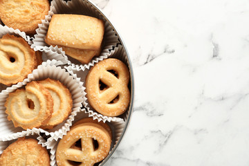 Tin box with Danish butter cookies on marble table, top view. Space for text