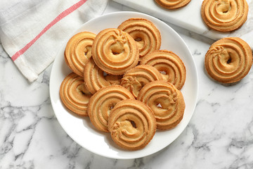 Plate with Danish butter cookies on marble table, top view