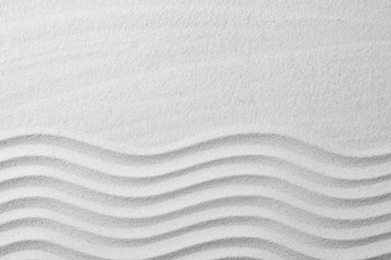 Fototapeta na wymiar Zen garden pattern on sand as background, top view with space for text. Meditation and harmony
